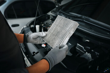 auto mechanic checking, cleaning and replacing car air filter. concept of car care service maintenan