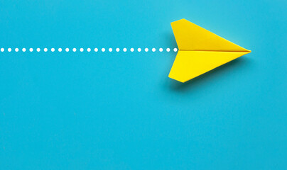 Wall Mural - Top view of yellow paper airplane on blue background with customizable space for text.