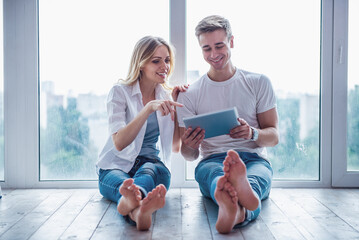 Beautiful young couple with gadget