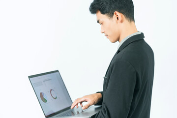 Young Asian man in black suit standing working with laptop, on white background
