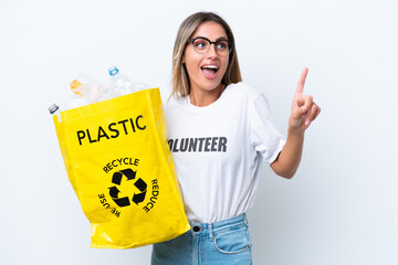 Canvas Print - Young pretty Uruguayan woman holding a bag full of plastic bottles to recycle isolated on white background intending to realizes the solution while lifting a finger up