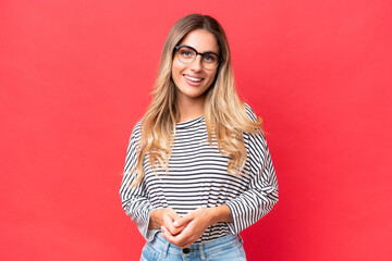 Young Uruguayan woman isolated on red background laughing