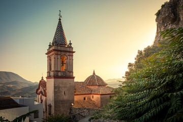 Canvas Print - View of the tower and dome of the Church of Santa Maria de la Mesa, at dawn in a natural environment of the town of Zahara de la Sierra, Cadiz, Andalusia, Spain