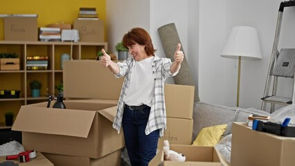 Poster - Middle age woman smiling confident doing thumbs up gesture at new home