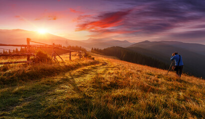 Aufkleber - Amazing nature scenery. Alone hiker, photographer taking a picture Majestic mountains during sunset. Stunning sunset in the mountains landscape with sunny beams. Carpathian mountains, Ukraine, Europe.