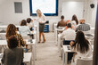 © qunica.com - Blonde business teacher helping a handicapped male person with the test