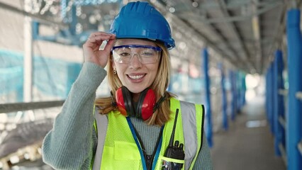 Wall Mural - Young blonde woman builder smiling confident standing at street