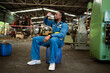 © KANGWANS - Worker drinking water from bottle on construction site. Male construction worker sitting and drinking water in a factory.