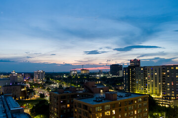 Wall Mural - aerial shot of a gorgeous summer landscape with skyscrapers, hotels, office buildings and tower cranes in the city skyline at sunset with cars driving on the street and green trees in Atlanta Georgia