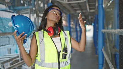 Wall Mural - African american woman builder using hardhat as a hand fan at street