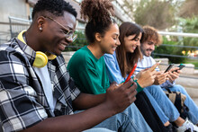Group Of Happy Multiracial Teenage College Friend Students Ignoring Each Other Looking At Mobile Phone. Phone Addiction.