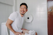 Funny happy face of asian man able to poop after suffer from constipation.