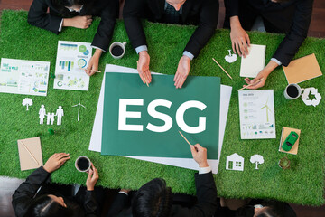 Top view panoramic banner ESG symbol on green grass meeting table with group of diverse business people planning marketing with eco-friendly awareness as environmental social governance concept.Quaint