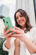 © Jose Calsina - Vertical. Lady using a mobile phone to do online shopping or having video call. Entrepreneur woman having fun with her cellphone watching the social media, sending messages or browsing on internet
