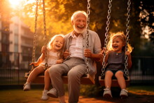 Old Man Laughing With His Grandchildren On A Swing In The Park.