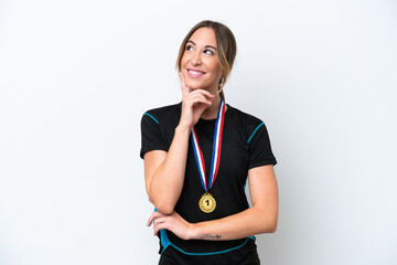 Wall Mural - Young caucasian woman with medals isolated on white background thinking an idea while looking up