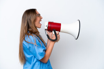 Young surgeon doctor woman isolated on blue background shouting through a megaphone