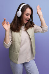 Wall Mural - positive young brunette woman with wireless headphones comes off during a break