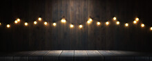 Empty Wooden Table In A Bar Or Restaurant. Garland Of Colored Light Bulbs On The Wall Of A Bar Or Restaurant, Space For Your Task Or Message. 3d Render.