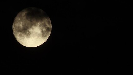 Wall Mural - Black clouds fly by in front of the full moon against the background of a black night sky