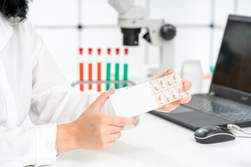 Poster - female pharmacist takes capsules out of package