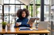© Wasana - Young black woman resting mood with coffee and reading report.