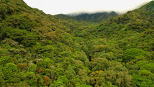AERIAL: Rainforest At The Foothill Of Volcan Baru With Mists Rolling Over Ridge