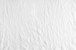© katyamaximenko - Wrinkled, crumpled white fabric texture background. Wrinkled and creased abstract backdrop of cotton jersey textile, wallpaper with copy space, top view.