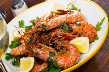 Wall Mural - Seafood dish. Delicious grilled shrimps served with parsley and lemon..