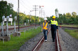 © somchai20162516 - Asian railway engineer inspects a train station Engineer working on maintenance inspection in railway station