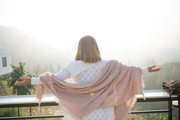 Wall Mural - asian woman stands with her back to camera and enjoys the view of forest. and looking mountain view in morning sunrise with copy space. trip and relaxing. Travel vacations and lifestyle concept.