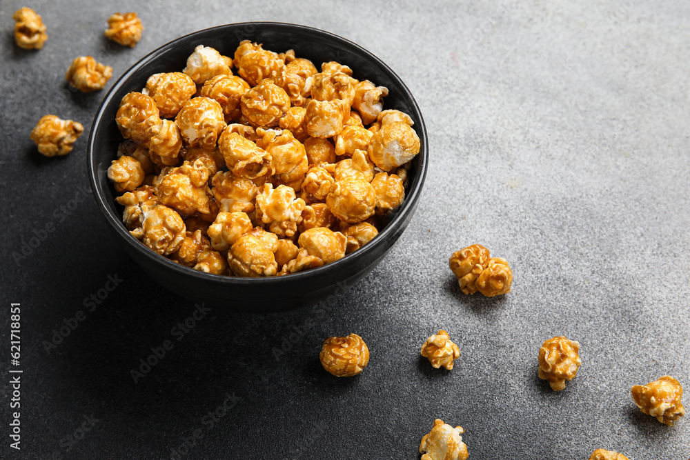 Bowl with tasty popcorn on grey background