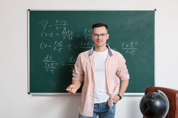 Canvas Print - Male Math teacher near chalkboard in classroom