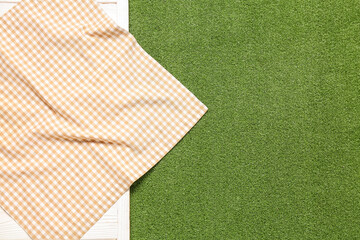 Wall Mural - Clean napkin on light wooden table against green grass background