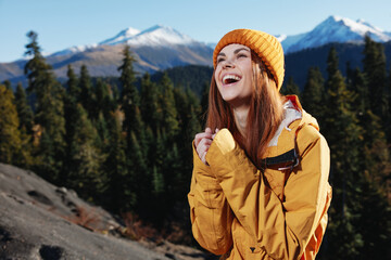 Canvas Print - Woman smile with teeth happiness and laughter tourist in yellow raincoat travel in the fall and hiking in the mountains in the sunset sunshine freedom