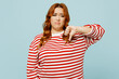 Young unhappy sad chubby overweight woman she wear striped red shirt casual clothes showing thumb down dislike gesture isolated on plain pastel light blue background studio portrait Lifestyle concept