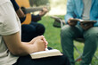 © Pcess609 - Christian Bible Study Concepts. Christian friend groups read and study the bible together in the park. sharing the gospel with a friend and holding each other's hand praying together. praying to God