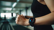 © Robert Kneschke - Woman wearing fitness tracker smartwatch while exercising in gym