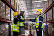 © APchanel - Industry warehouse worker in safety uniform check order details and checking goods supplies on boxes shelve in workplace warehouse industry logistic export import distribution business concept.