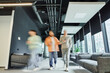 © LIGHTFIELD STUDIOS - motion blur of modern entrepreneurs in casual clothes walking along lounge corridor with comfortable couches in coworking office with high tech interior, movement, collaboration, dynamic business