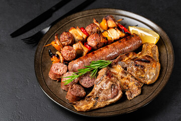 Italian assortment of grilled meats on a brown plate - grigliata di carne mista. Lamb, beef, sausage, mix meat and vegetables skewers. Dark background.