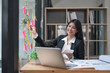 © Natee Meepian - Business Asian woman smile at office and use post it notes in glass wall to warn. business asian woman office concept. Sticky note on glass wall