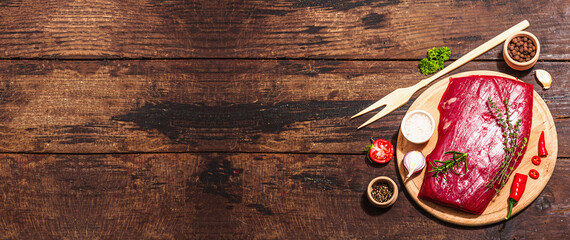 Wall Mural - Close up of Flank steak with traditional spices and herbs. Fresh raw meat cut, wooden background