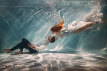 happy couple in love swim underwater, female goddess muse inspires male writer poet creator. nymph g