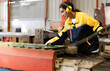 © Nassorn - Female industrial engineer in safety jacket work in heavy metal production engineering factory. Latin technician woman wearing headphone working in metalwork manufacturing and warehouse facility.
