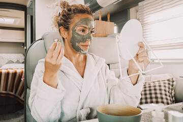 Wall Mural - One attractive adult middle age young woman using natural product treatment facial mask for age and wrinkles wellness body care and daily routine of self-love. Healthy lifestyle female people indoor