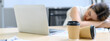Two coffee paper cups on table with a tired business Asian woman sleeping in the background. working overtime concept. Select focus to paper cup. Banner cover design.