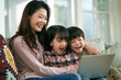 © imtmphoto - young asian mother and two children using laptop computer together