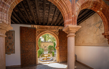 Sticker - One of the interior patios of El Palacio de Mondragn, a historic Mudejar-Renaissance building located in the old town of Ronda, Malaga, Spain with a door leading to the outside garden