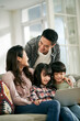 © imtmphoto - young asian couple and two children using laptop computer together at home
